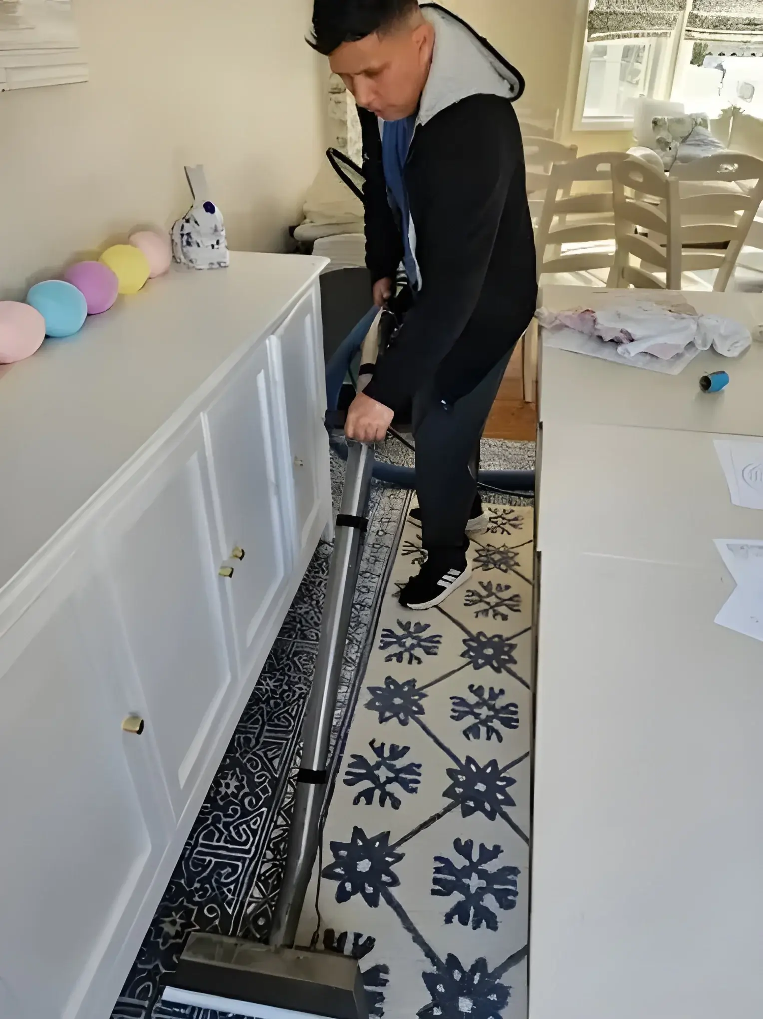 Technician steam cleaning a patterned carpet runner in a New York home on a same-day visit